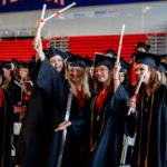 Students in caps and gowns lift their diplomas in celebration during Shenandoah University's 2022 毕业典礼